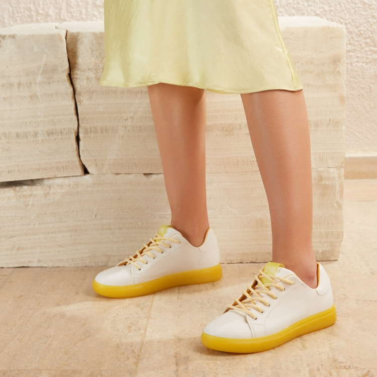 Белые кроссовки с желтой подошвой