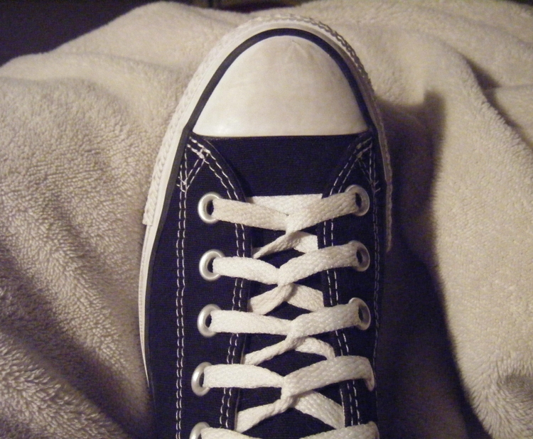 Белые шнурки на черных кроссовках